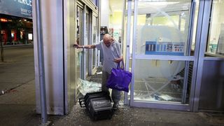 A man walks out of a looted Walgreens in Times Square